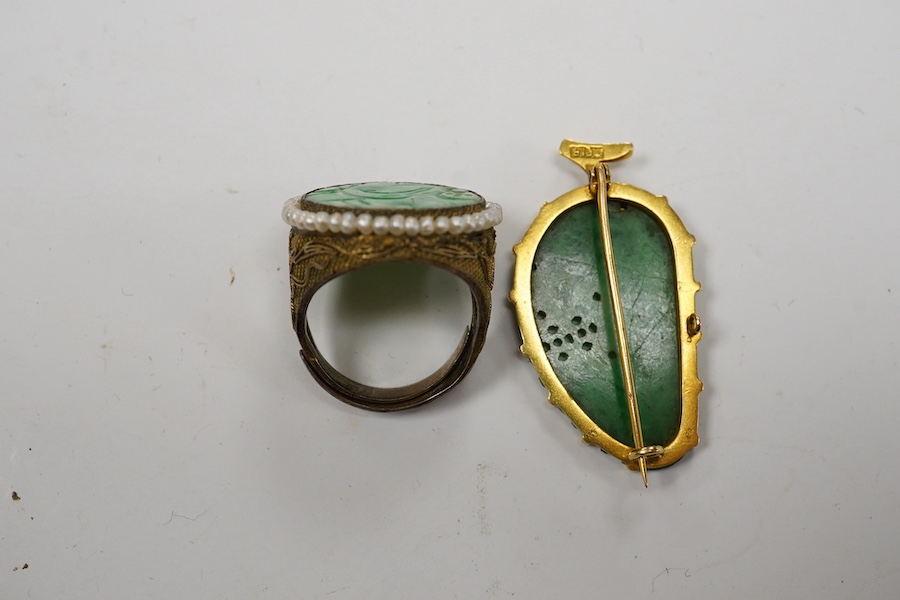 A Chinese yellow metal mounted carved jade leaf brooch, stamped 'TC18', 36mm, gross weight 5.6 grams and a jade and seed pearl set filigree ring. Condition - fair to good